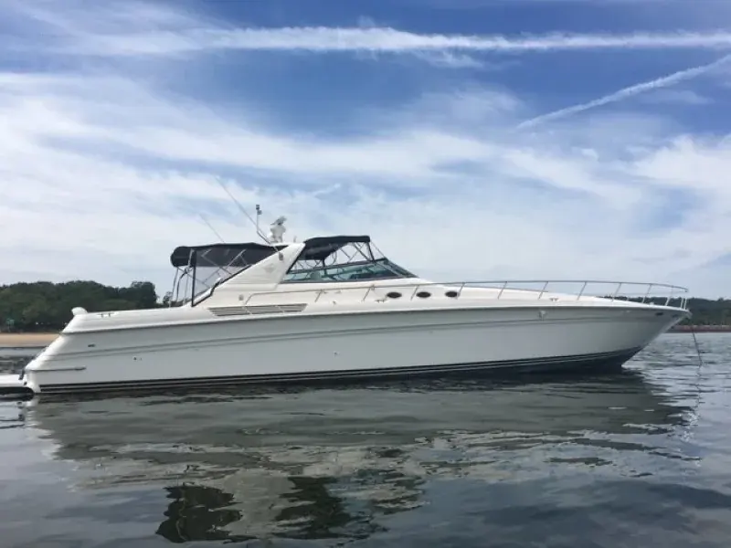 1993 Sea Ray 63 Super Sun Sport “Precious Cargo”: open express cruiser at anchor, white hull with navy canvas over cockpit and windshield