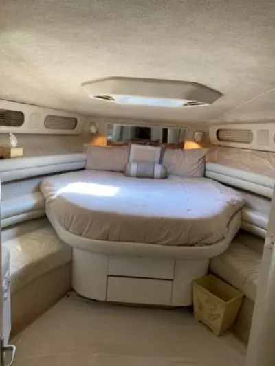 1993 Sea Ray 63 Super Sun Sport “Precious Cargo”: forward stateroom with island berth, cream upholstered side seating and overhead hatch