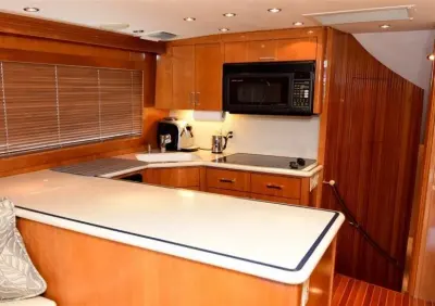 2001 Hatteras 60 Convertible “Reel Energy”: galley with cherry cabinetry, white solid-surface counters, microwave and ceramic cooktop