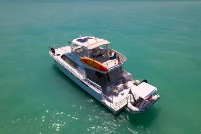 2002 Wright/Lavranos 50 Power Catamaran “Peace”: aerial stern view of power catamaran with tender on davits, kayaks and flybridge seating