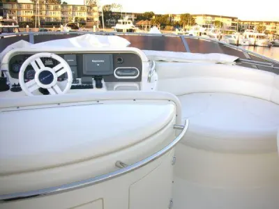 2006 Azimut 55 Flybridge: flybridge helm with white steering wheel, chartplotter and cream curved lounge seating