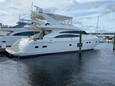 2009 Princess 70 Flybridge “Social Services”: stern-quarter view of docked flybridge yacht showing teak swim platform and enclosed hardtop