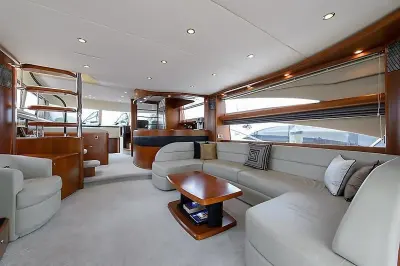2009 Princess 70 Flybridge “Social Services”: salon with grey leather U-shaped settee, cherry coffee table and bar with stairs beyond