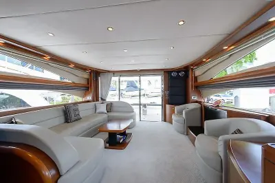 2009 Princess 70 Flybridge “Social Services”: salon looking aft to sliding glass doors, grey leather settee and twin swivel chairs