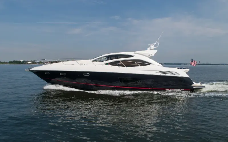 2010 Sunseeker 64 Predator “Bella”: sport yacht cruising with navy hull, red boot stripe and white superstructure