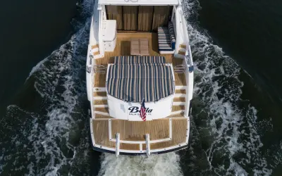 2010 Sunseeker 64 Predator “Bella”: overhead stern view underway showing teak cockpit, striped sunpad and teak swim platform
