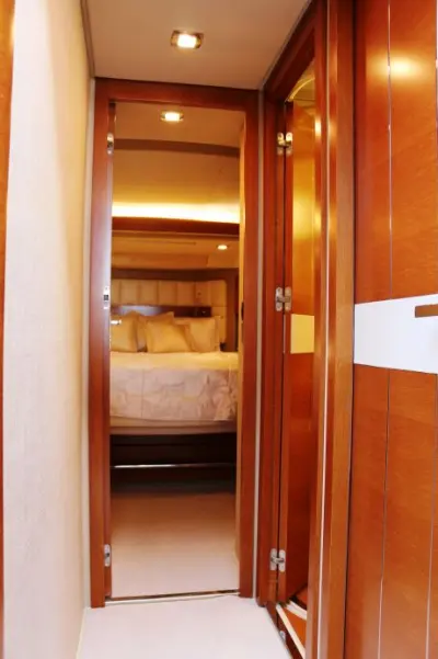 2013 Azimut 64 Flybridge “Vivere”: wood-panelled lower deck passageway with open door to stateroom double bed