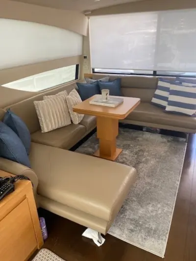 2013 Pershing 64 “Sound View”: salon with taupe leather L-shaped sofa, oak pedestal table and blue striped cushions