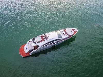 2013 Pershing 82 “Milagros”: high aerial of silver sport yacht showing teak swim platform, aft sunpads and foredeck lounge