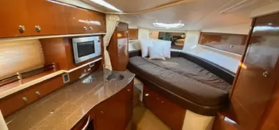 2014 Sea Ray Sundancer 33 “Peace of Mind”: cabin with cherry-wood galley, sink and microwave beside a brown cushioned settee berth
