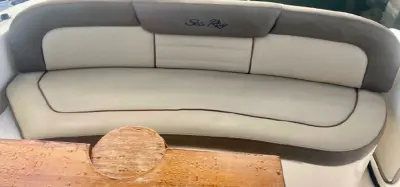2014 Sea Ray Sundancer 33 “Peace of Mind”: cockpit curved bench seat in cream and taupe upholstery behind a wooden table