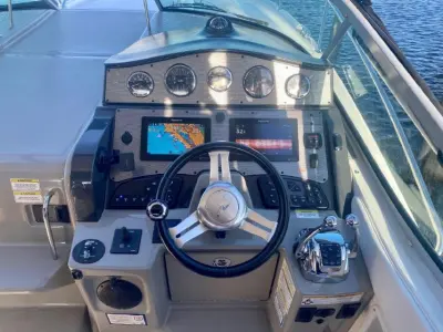 2014 Sea Ray Sundancer 33 “Peace of Mind”: helm dashboard with five analog gauges, twin chartplotter displays and steering wheel