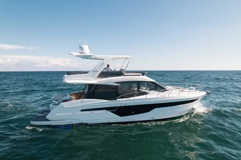 2020 Galeon 500 Fly “Livin the Dream”: flybridge motor yacht cruising in open water, white hull with black window band, guest on flybridge