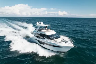 2020 Galeon 500 Fly “Livin the Dream”: aerial running shot at speed with white wake, bow lounge and flybridge hardtop