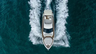 2021 Ferretti Yachts 550 “Haven”: top-down aerial at speed showing teak side decks, bow sunpad and flybridge layout