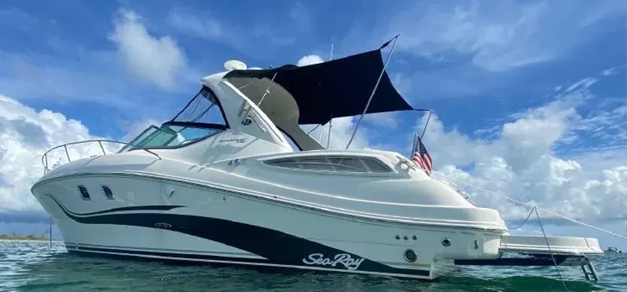 An express cruiser with a dark canvas bimini at anchor